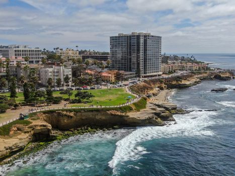 Aerial view of La Jolla coast, San Diego, California. Beach and blue sea with small waves. Hilly seaside of curving coastline along the Pacific.