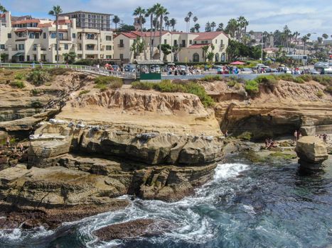 Aerial view of La Jolla coast, San Diego, California. Beach and blue sea with small waves. Hilly seaside of curving coastline along the Pacific.