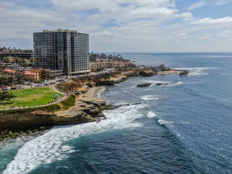 Aerial view of La Jolla coast, San Diego, California. Beach and blue sea with small waves. Hilly seaside of curving coastline along the Pacific.