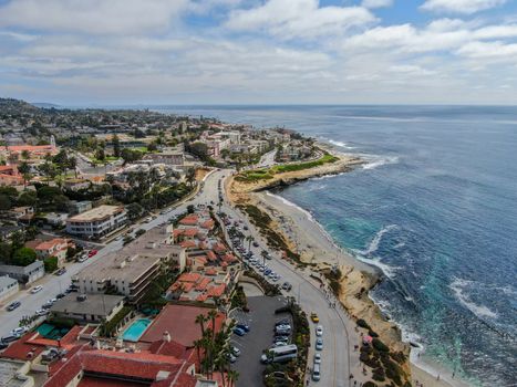 Aerial view of La Jolla coast, San Diego, California. Beach and blue sea with small waves. Hilly seaside of curving coastline along the Pacific.