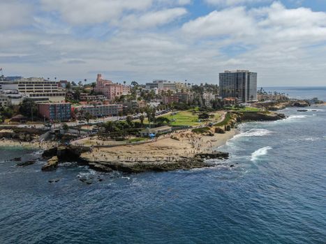 Aerial view of La Jolla coast, San Diego, California. Beach and blue sea with small waves. Hilly seaside of curving coastline along the Pacific.