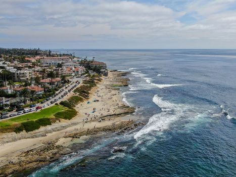 Aerial view of La Jolla coast, San Diego, California. Beach and blue sea with small waves. Hilly seaside of curving coastline along the Pacific.