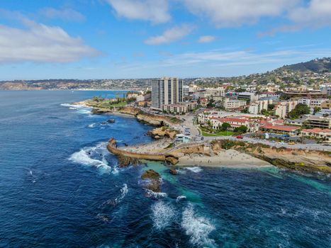 Aerial view of La Jolla coast, San Diego, California. Beach and blue sea with small waves. Hilly seaside of curving coastline along the Pacific.