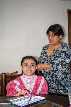woman putting makeup on girl of a typical mexican Catrina