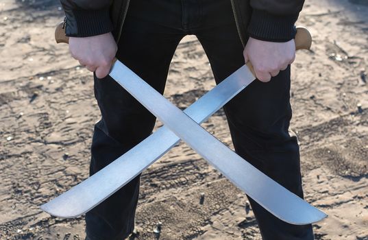 The man in the leather jacket, holding a crossed machete