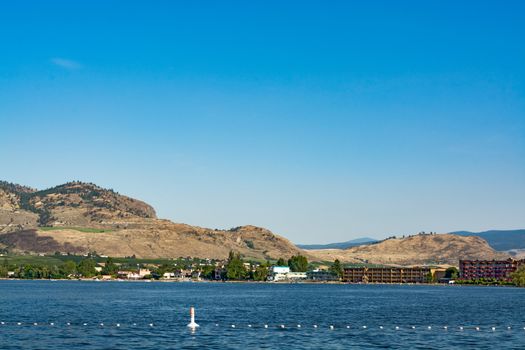 Resorts on Osoyoos lake shore with blue sky and mountain background. Okanagan valley view