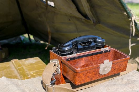 old military wired phone stands on the table in the army tent