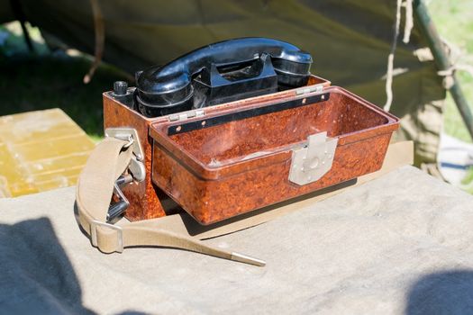 old military wired phone stands on the table in the army tent