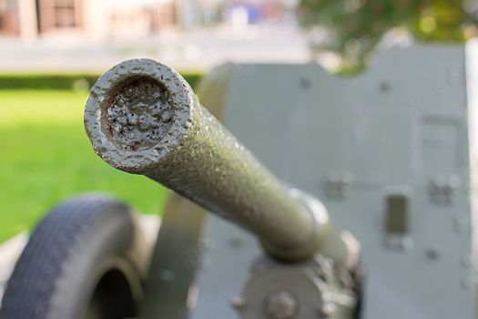 a sample of a military cannon close-up on the background of a residential area