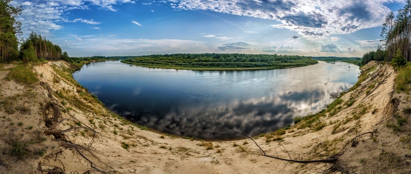 river and field at sunset under a high sandy cliff, panorama with fish-eye effect