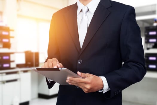 Business people with tablet ,digital technology concept. Young Asian business man working on digital tablet while standing in office background. light effect