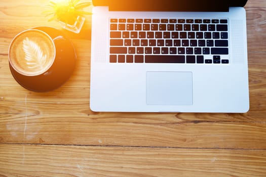 work space concept. laptop, top view of workplace with laptop on wood table with coffee cup with copy space for your text