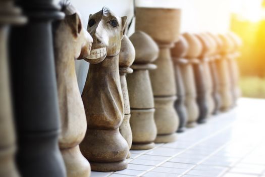 Funny face on knight of chess made from wooden. Face to face knight of chess with toothy smile. selective focus and warm light effect