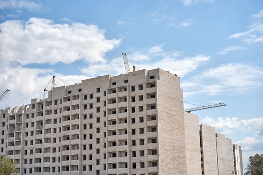 Crane building construction site blue cloudy sky background Construction brick multi-storey building. New residential area for living