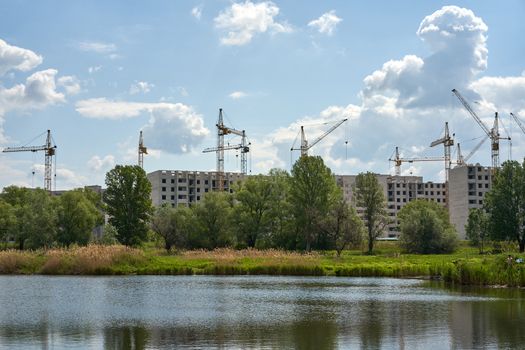 Crane building construction site blue cloudy sky background Construction brick multi-storey building. New residential area for living