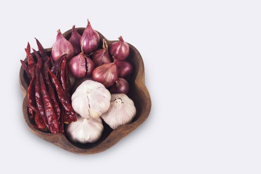 Thai spices on wooden plate. Dried chilies, shallots and garlic isolate on white background with clipping path