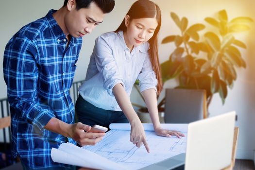 Construction , designer and renovate concept. - Architects working with blueprints in the office. Confident team of young Asian engineers working together in a architect studio