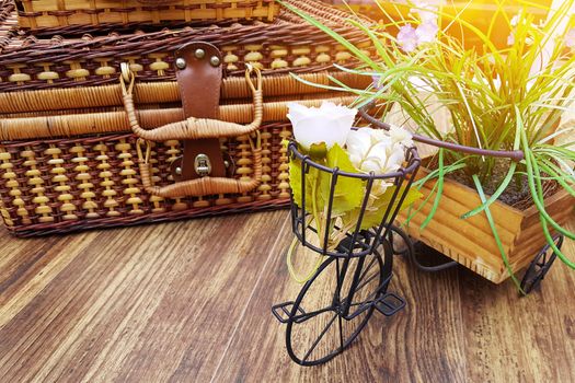 summer vacation concept. vintage suitcase on the table decorated with flower pot in small bicycle shape. copy space on wooden table