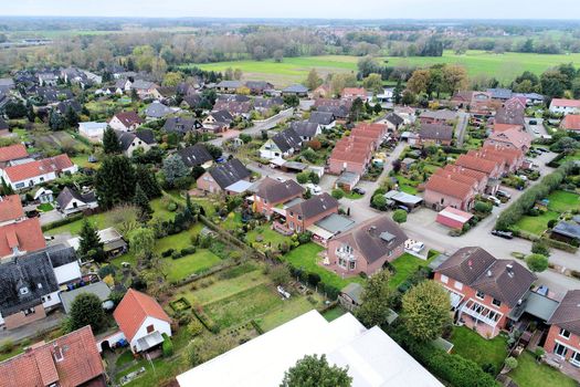  Suburban settlement in Germany with terraced houses, home for many families, aerial photograph taken at a slanting angle with the drone