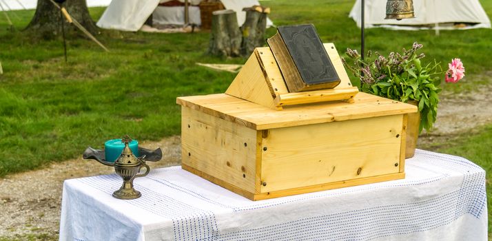 Christian open-air church, table as pulpit with an old bible, outside church, simple church