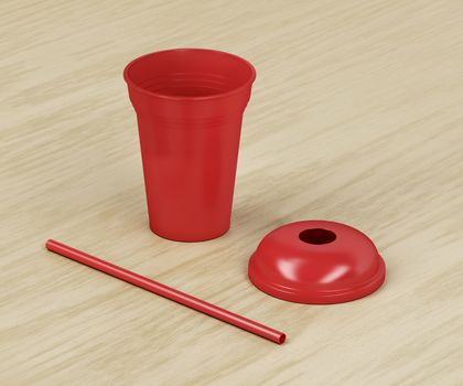 Red disposable plastic cup for cold drinks with a straw on wood background