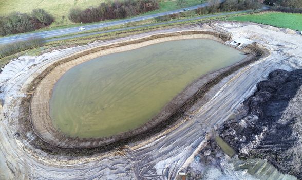 Aerial view of the rainwater retention basin under construction in a new development area, oblique image with drone