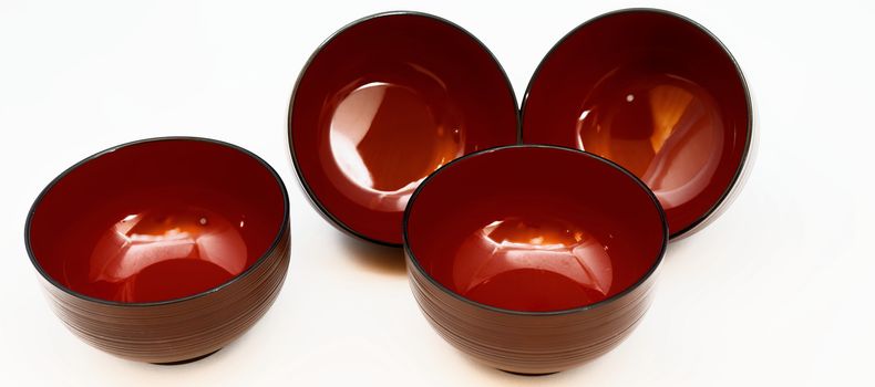 Still life of four Japanese lacquer bowls for miso soup or noodle soup, isolated