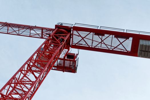 Red high construction crane on a building site, oblique picture of an abstract image effect, dramatic sky.