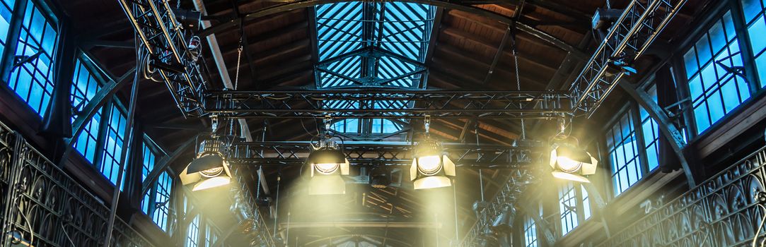 Spotlight on the ceiling of a former factory hall for lighting during a concert with rock music