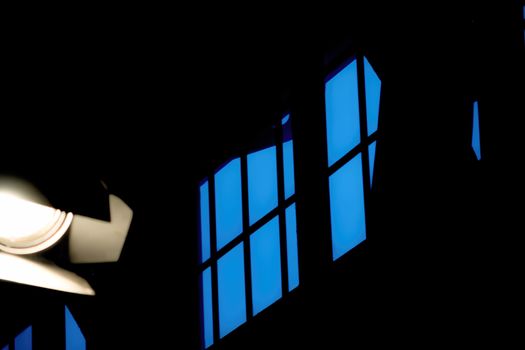 Abstract picture of a window frame with a dark blue sky and a cropped spotlight in the front.