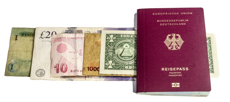 Banknotes from USA, Uganda, England, Turkey and Jordan under a passport from Germany against a white background, isolated