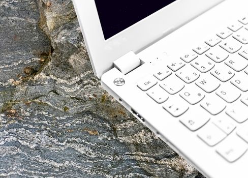 Laptop, with low depth of field, taken on a gneiss from the Palaeozoic, photomontage