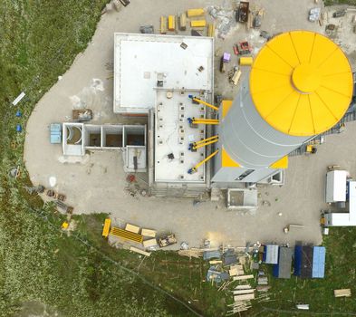 Construction site for an industrial plant for the production of concrete, taken vertically from the air, aerial view with a drone