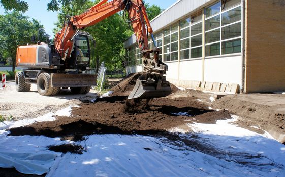 Covers of a geotextile as' protection against toxic soil contamination. Application of clean soil with the excavator