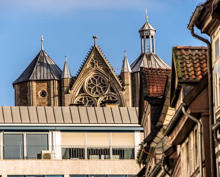 The old façade of the cathedral behind a new department store in Braunschweig, Germany with houses of the old town in front.