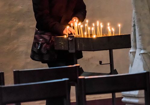 Light a candle in a Christian church to commemorate the deceased.