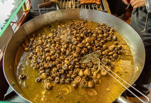 Pan with mushrooms in oil at the Christmas market in Braunschweig, Germany, detail view