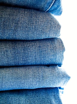 Pile of different blue jeans, fabric texture