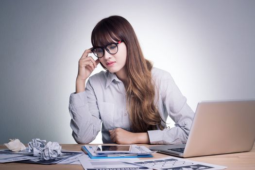 Feeling sick , stressed and tired. Stress young business woman of working age is working on a wooden table at her working place in office feel under pressure. Asian woman model in her 30s