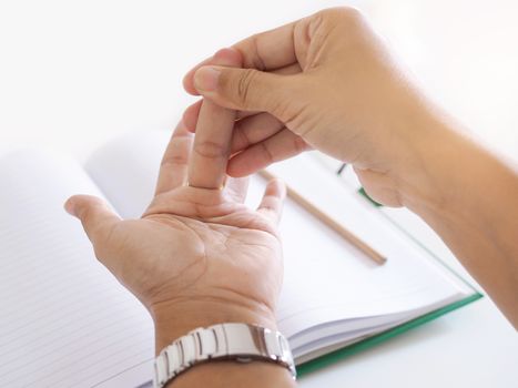 Young Asian working woman suffering hand pain, trigger finger and massage on painful middle finger.