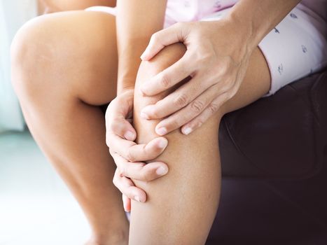 asian women sit and have knee pain, Leg ache, joint pain and muscle injuries.