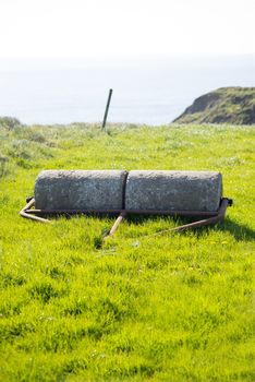 old rustic concrete roller abandoned at a field in ireland