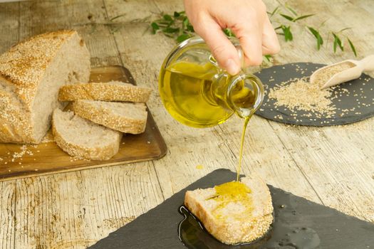 Closeup of woman hands pouring extra virgin olive oil from an am