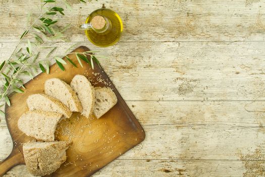 Close-up of a sliced loaf of homemade bread with sesame seeds, ampoule of ext