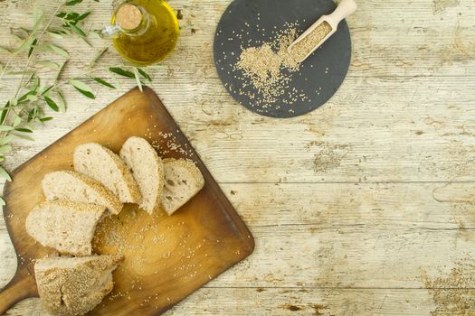 Close-up of a sliced loaf of homemade bread with sesame seeds, a