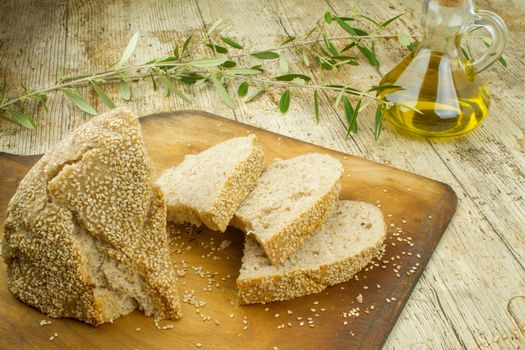 Close-up of a sliced loaf of homemade bread with sesame seeds, a