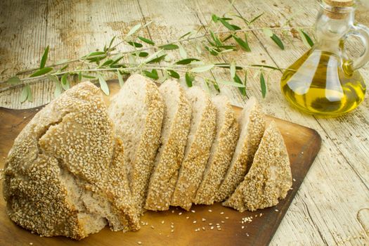 Close-up of a sliced loaf of homemade bread with sesame seeds, a