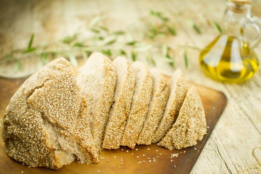 Close-up of a sliced loaf of homemade bread with sesame seeds, a