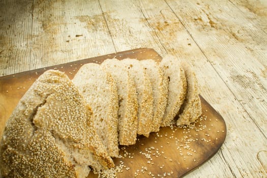 Close-up of a sliced loaf of homemade bread with sesame seeds o