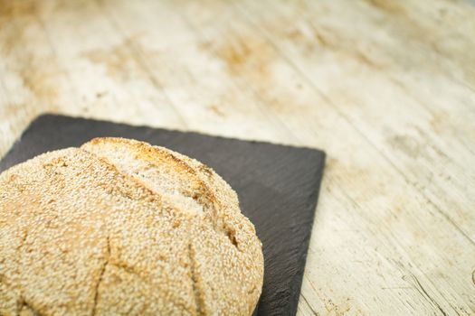 Close-up of a loaf of homemade bread with sesame seeds in select